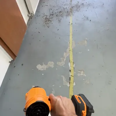 The SuperLeafBlower aimed at grit on a garage floor