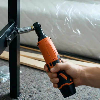 The SuperRatchet with a socket on a corner bolt of a black metal bed frame being put together