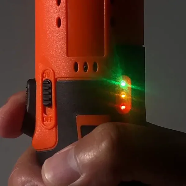 Green, amber and red battery-gauge lights glowing on the SuperRatchet's grip beside the ON/OFF switch